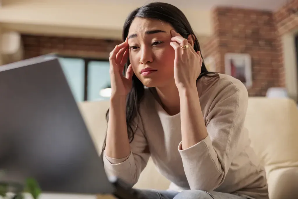 A burned-out employee struggling at their laptop