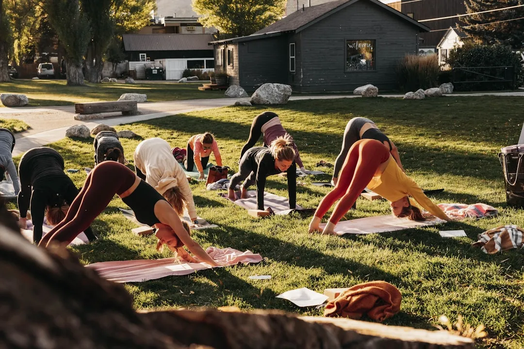 Employees participating in an outdoor yoga class - workplace wellness program ideas
